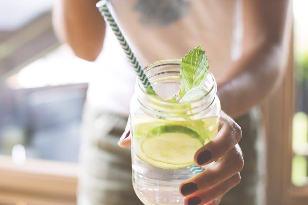 Woman,Holding,Glass,Of,Infused,Water,With,Cucumber,,Lime,And